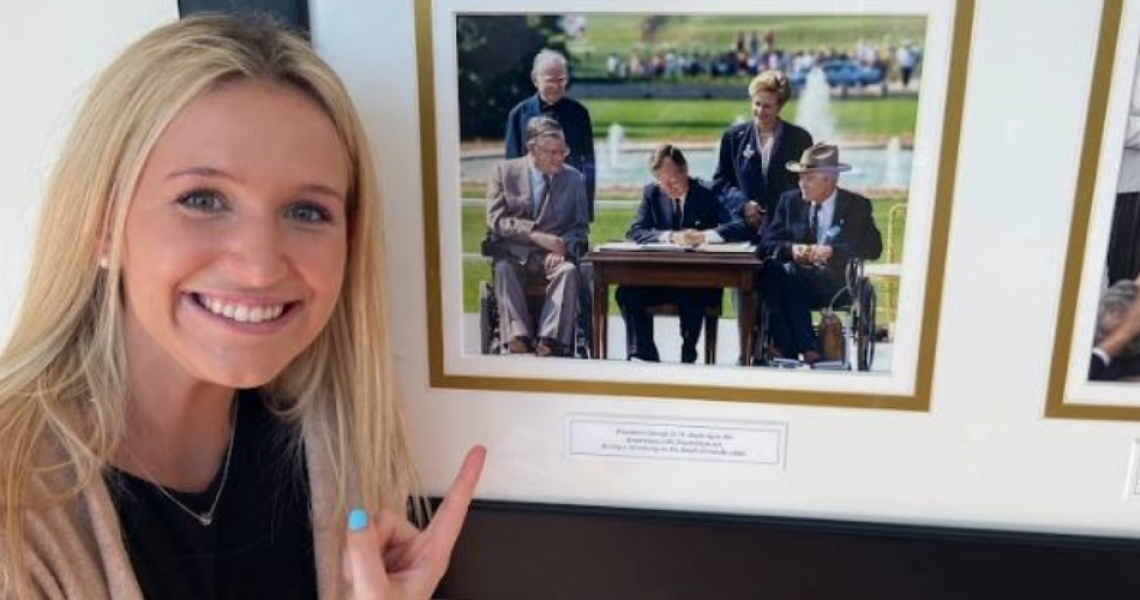 Alexis Clapper pointing at photo of ADA bill getting signed