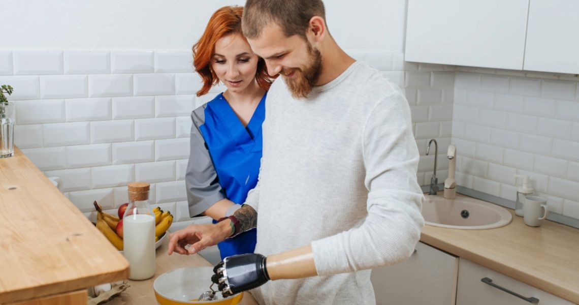 occupational therapist overlooking male with prosthetic hand cooking