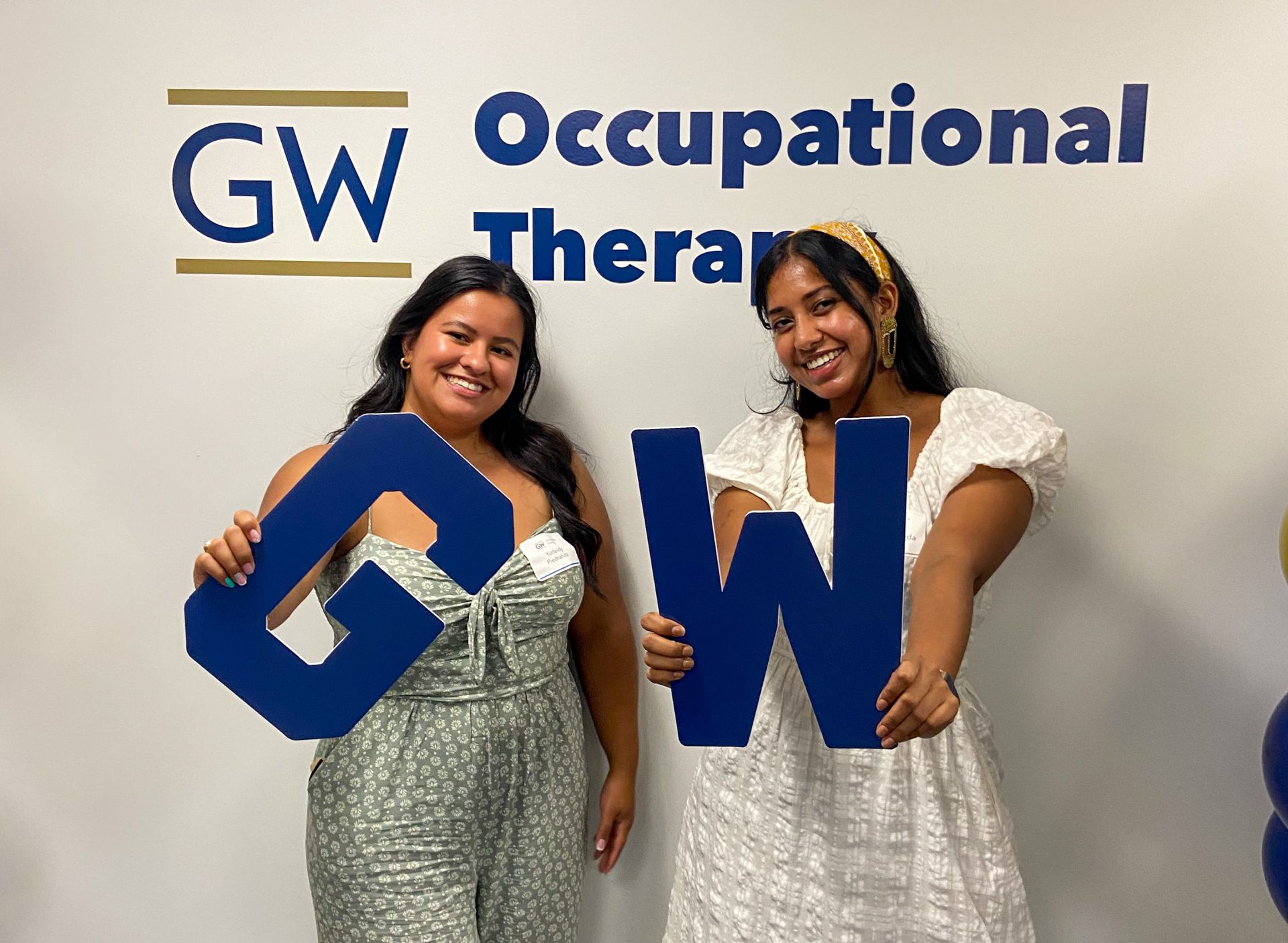 Student and Friend holding GW signs