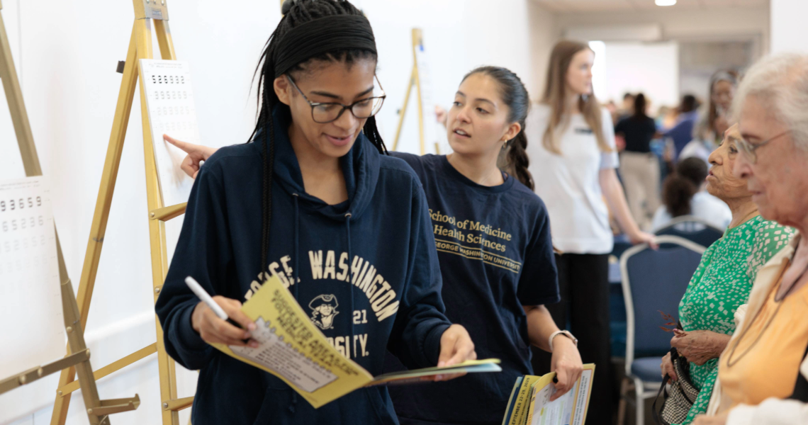 GW student at Falls Prevention Awareness Day vision screening with older adult